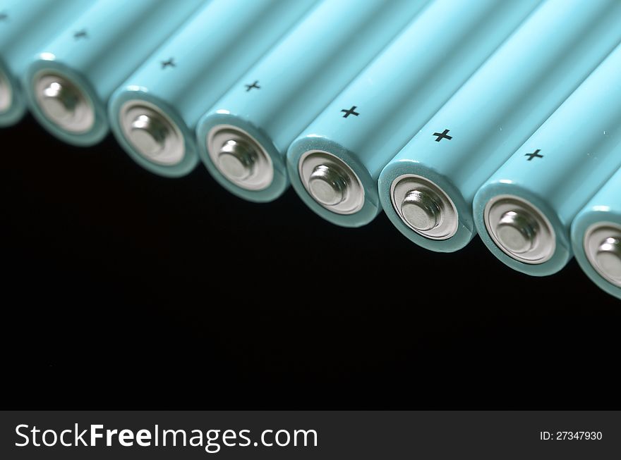 Set of AA batteries lined up on a black background