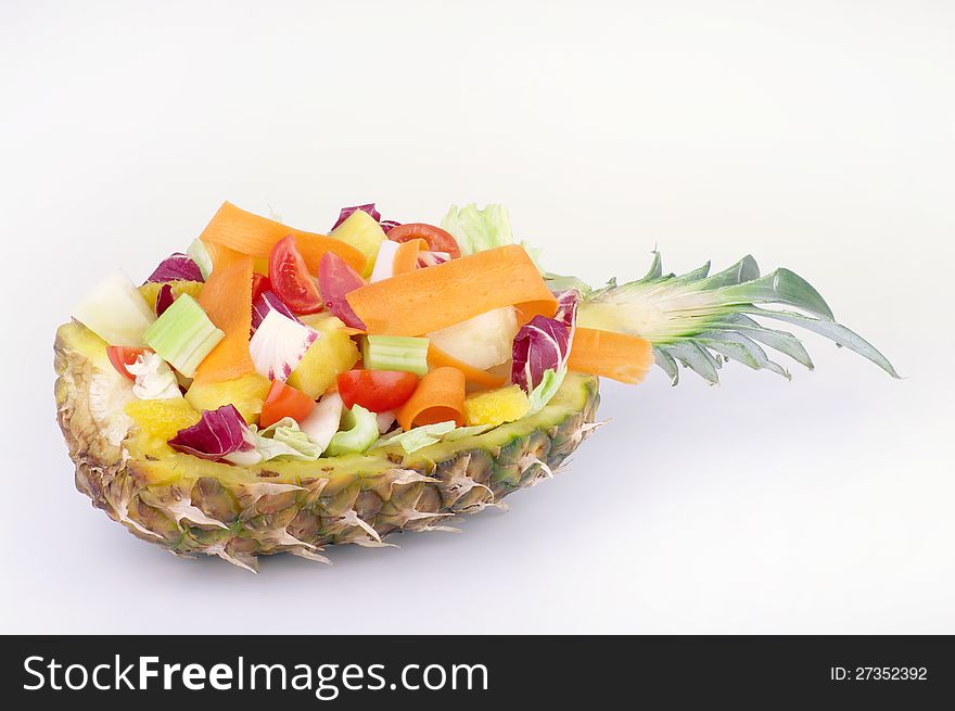 Bowl made from the peel of pineapple with fruit salad and vegetables