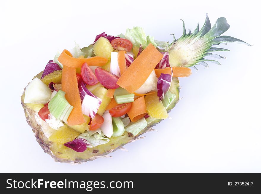 Bowl made from the peel of pineapple with fruit salad and vegetables