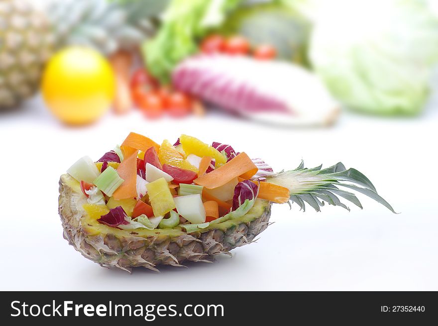 Bowl made from the peel of pineapple with fruit salad and vegetables