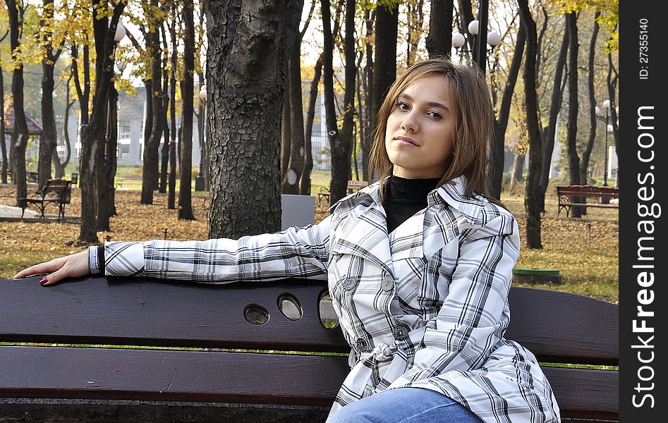 A girl sitting on a bench. A girl sitting on a bench