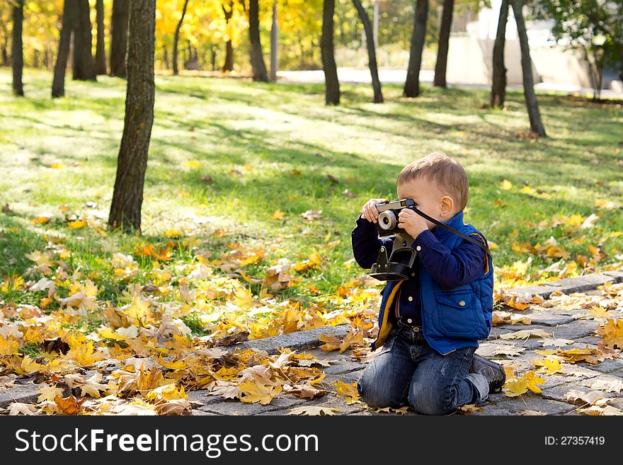 Small boy using a vintage slr camera