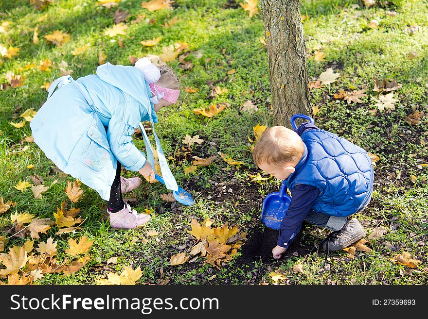 Children collecting yellow autumn leaves