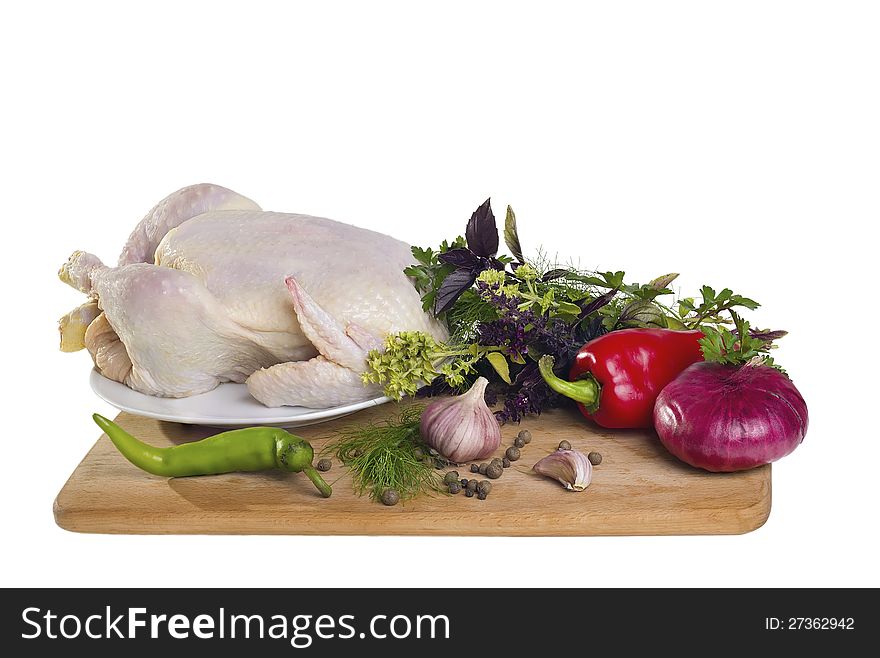 Raw chicken with vegetables on cutting board isolated on white