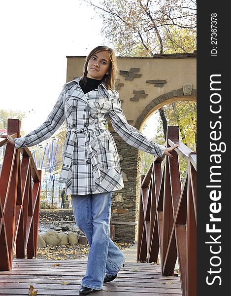 A girl, young woman, stands on a bridge. A girl, young woman, stands on a bridge