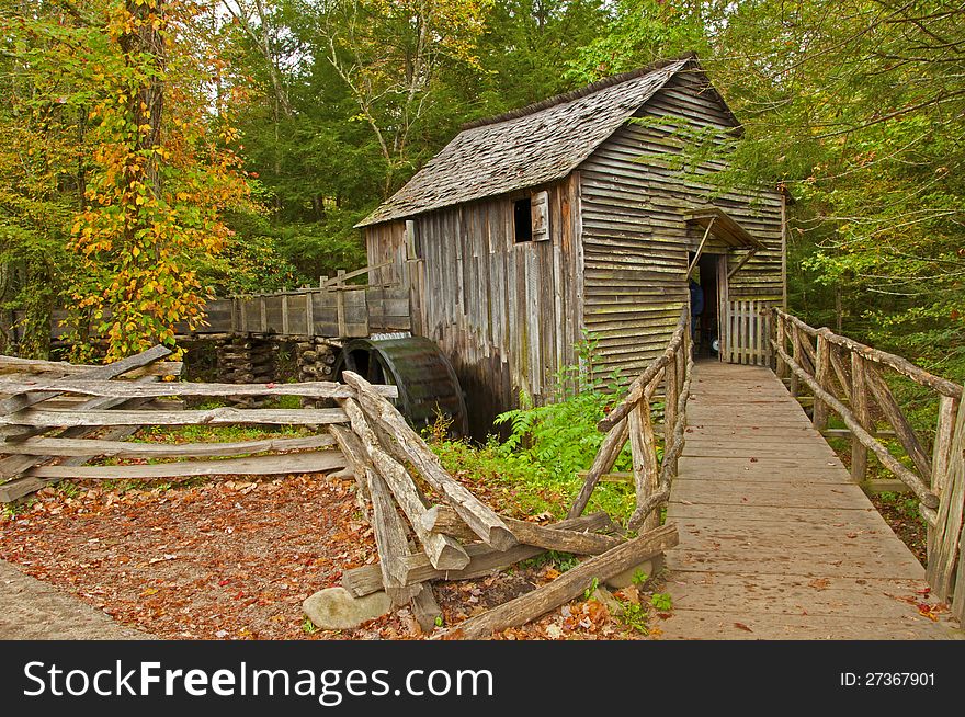 An old grist mill is surrounded with fall colors. An old grist mill is surrounded with fall colors.