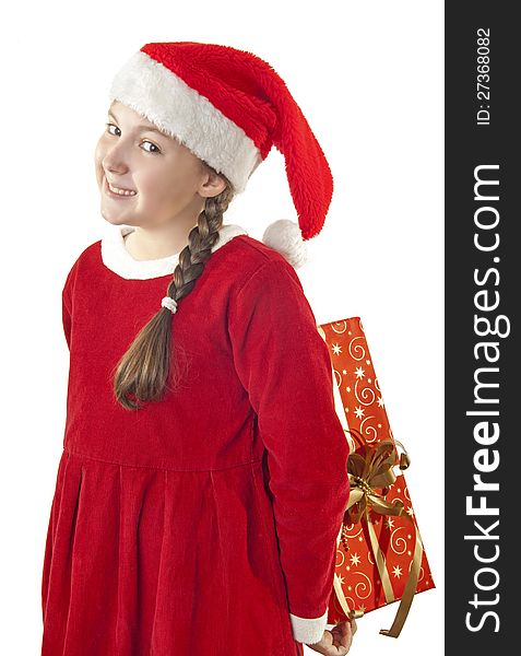 Beautiful girl dressed in Christmas clothes and red santa hat with present behind her back isolated on white background. Beautiful girl dressed in Christmas clothes and red santa hat with present behind her back isolated on white background