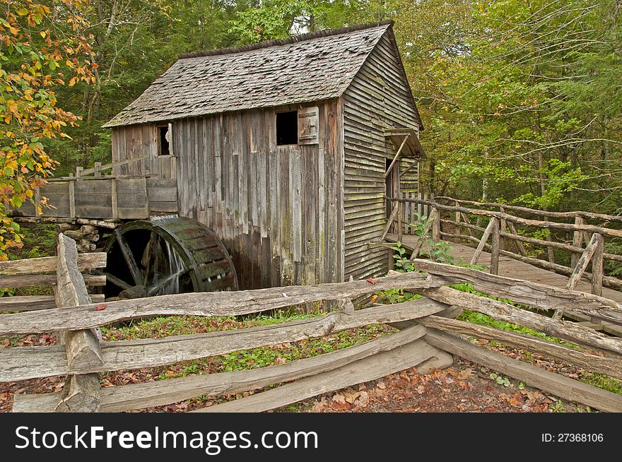 An old grist mill is surrounded with fall colors. An old grist mill is surrounded with fall colors.