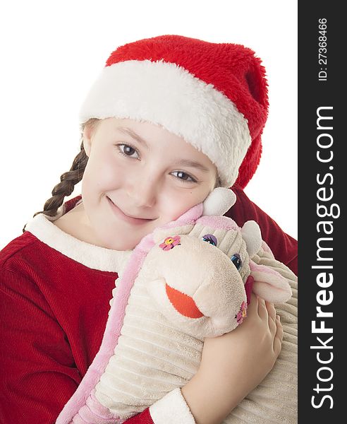 Beautiful girl dressed in Christmas clothes and red santa hat hugging cute cow pillow isolated on white background. Beautiful girl dressed in Christmas clothes and red santa hat hugging cute cow pillow isolated on white background