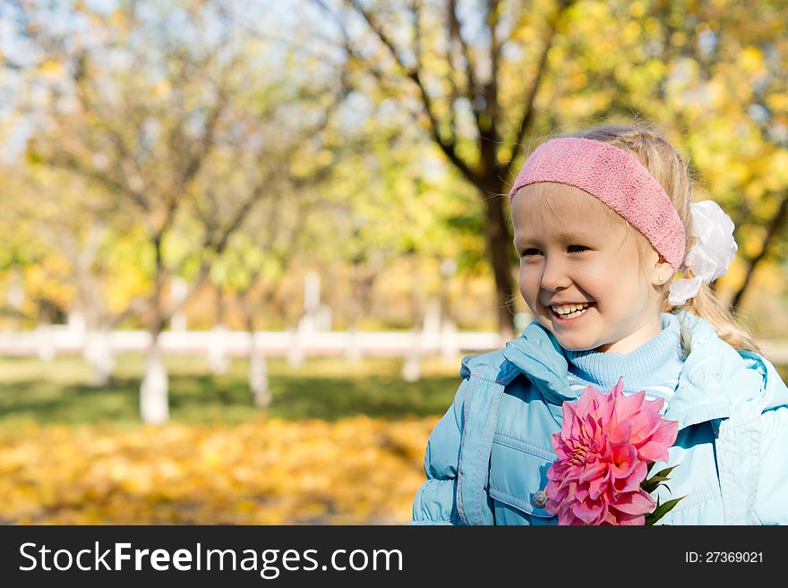 Smiling little girl with pink dahlia