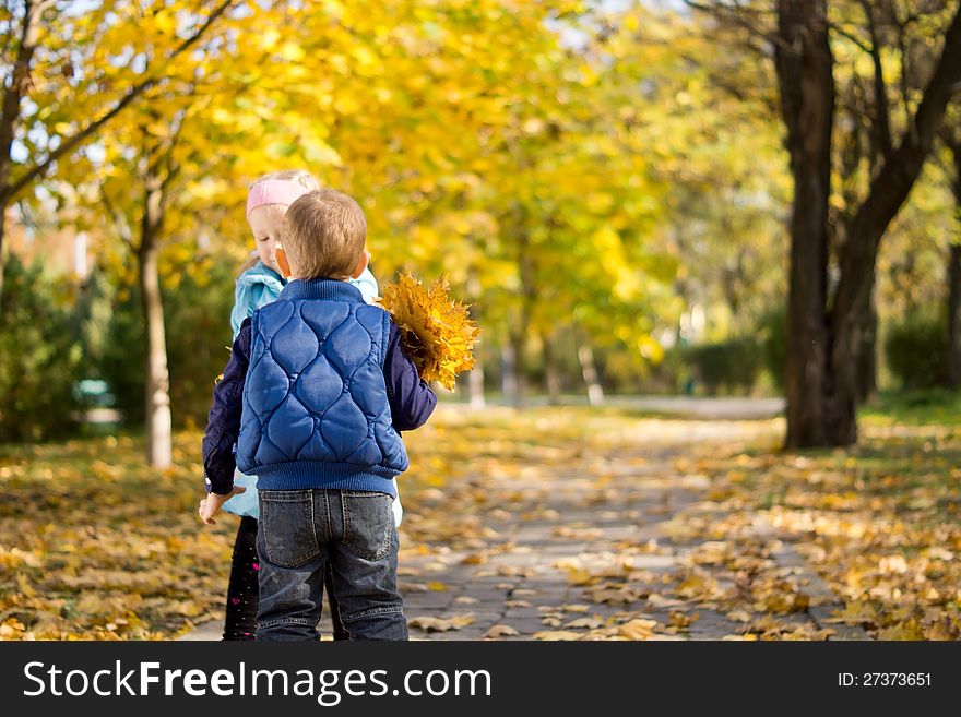 Young Boy And Girl With Yellow Autumn Leaves