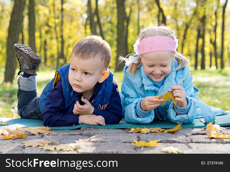 Small Children Relaxing in a Park in Autumn