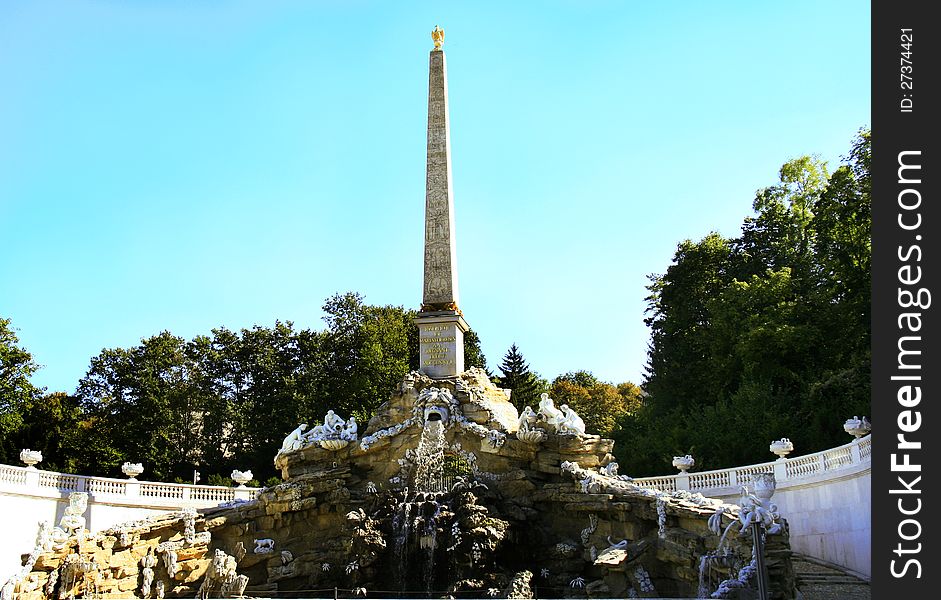 The grand obelisk fountain architectural ensemble in the gardens of Schonbrunn palace in Vienna Austria. The numerous statues decorating the central piece represent various allegories for Austrian rivers and nature. The main monolithic Egyptian obelisk rests atop the rock pedestal. The grand obelisk fountain architectural ensemble in the gardens of Schonbrunn palace in Vienna Austria. The numerous statues decorating the central piece represent various allegories for Austrian rivers and nature. The main monolithic Egyptian obelisk rests atop the rock pedestal.