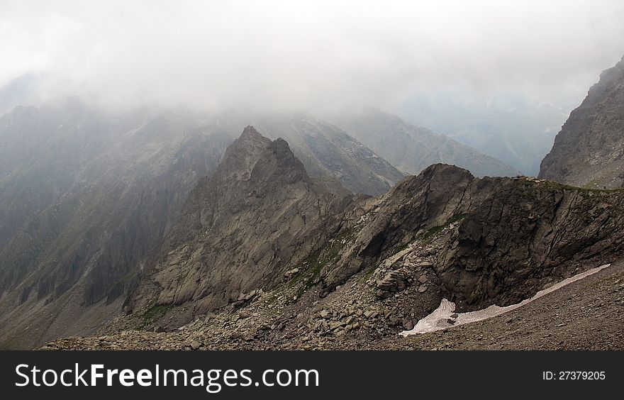 This image presents a beautiful picture with a mountain hiding behind the clouds in the summer. This image presents a beautiful picture with a mountain hiding behind the clouds in the summer.