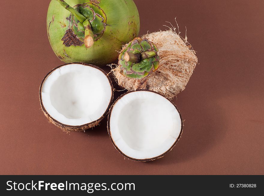 Two halfs of coconut  on brown background. Two halfs of coconut  on brown background