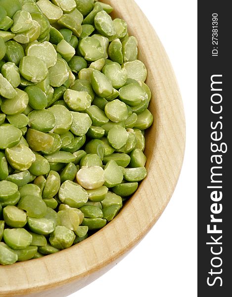 Green Split Peas in Wooden Bowl closeup on white background