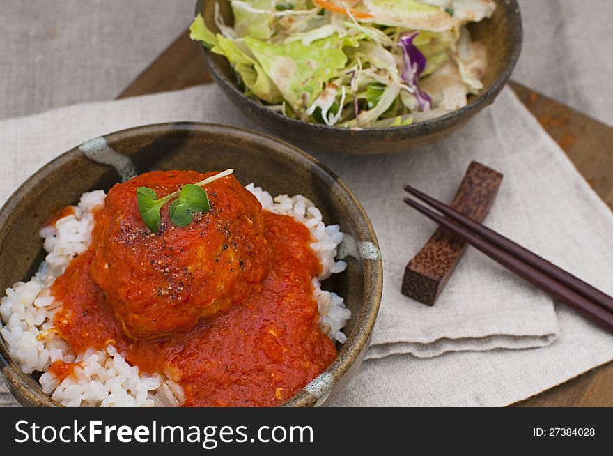 Meatballs on rice in a tomato sauce　salad