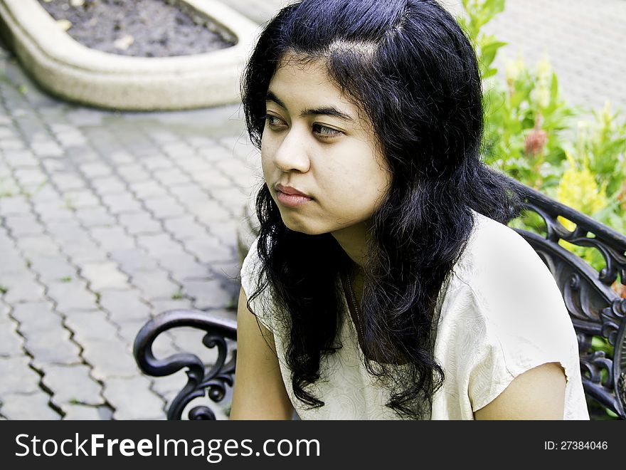 Sleepy girl sitting on a bench