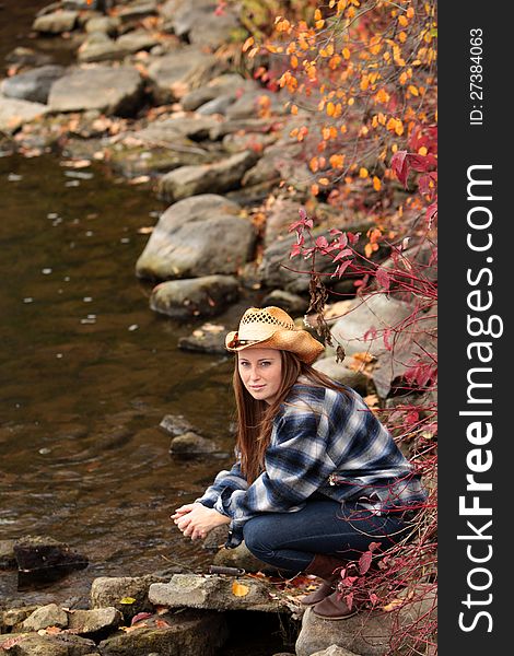 Pretty young girl at the riverside enjoying a beautiful day in autumn. Pretty young girl at the riverside enjoying a beautiful day in autumn.