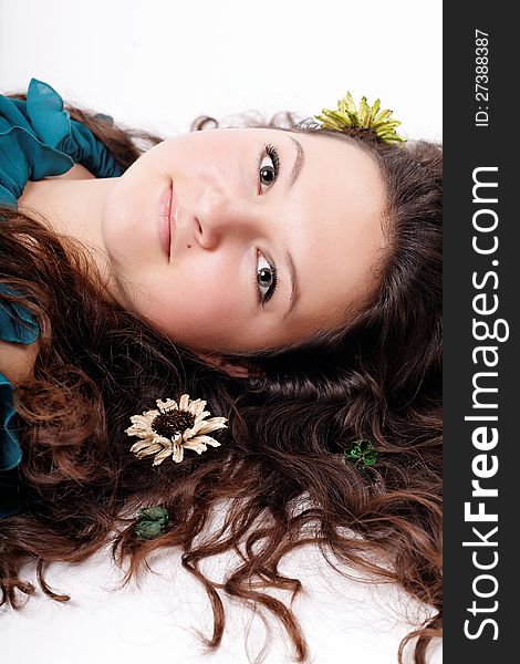 Portrait of brunette girl with flowers in her hair isolated