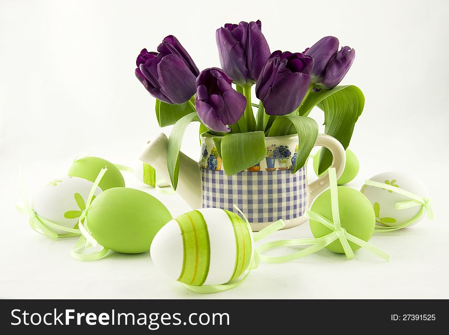 Easter eggs with watering can and color tulips. Easter eggs with watering can and color tulips