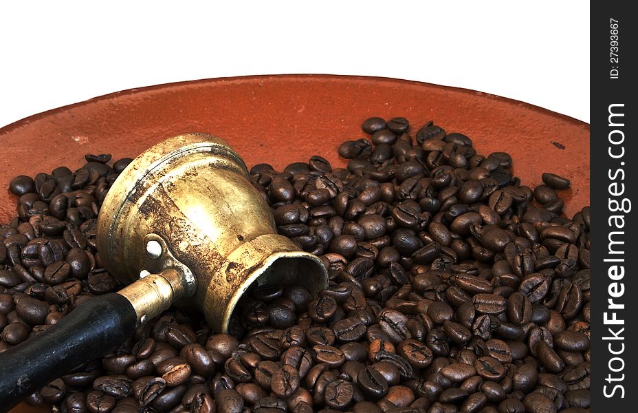 Arab coffee pot and roasted coffee beans on old ceramic plate over white background. Arab coffee pot and roasted coffee beans on old ceramic plate over white background