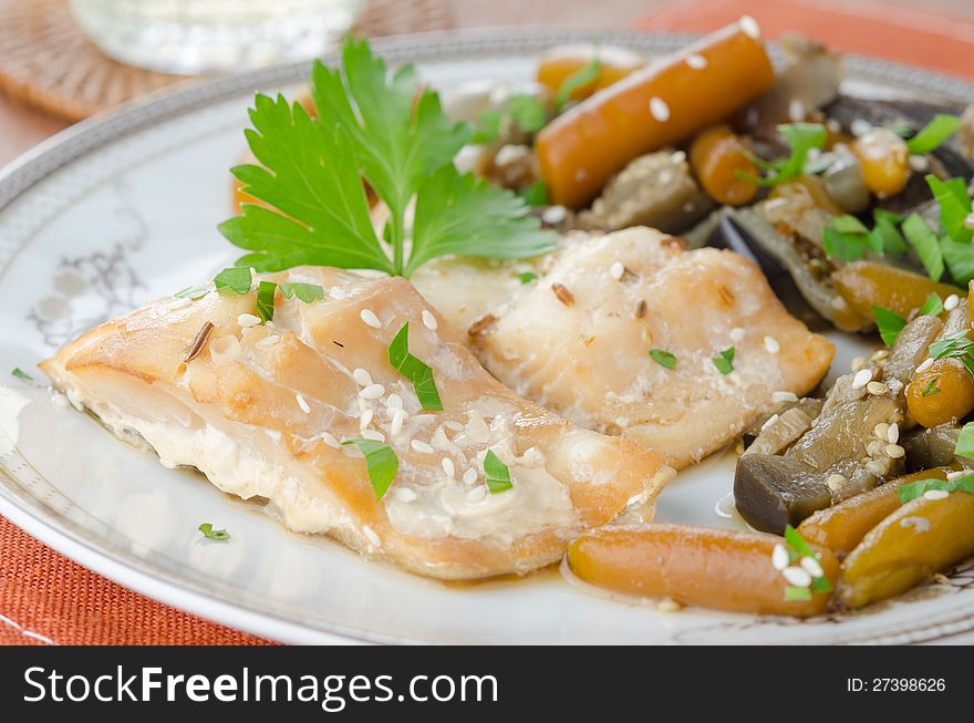 Sliced â€‹â€‹baked cod with vegetables on a plate. Sliced â€‹â€‹baked cod with vegetables on a plate