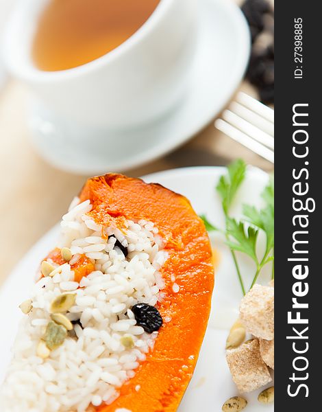 Baked pumpkin with rice and raisins and cup of tea