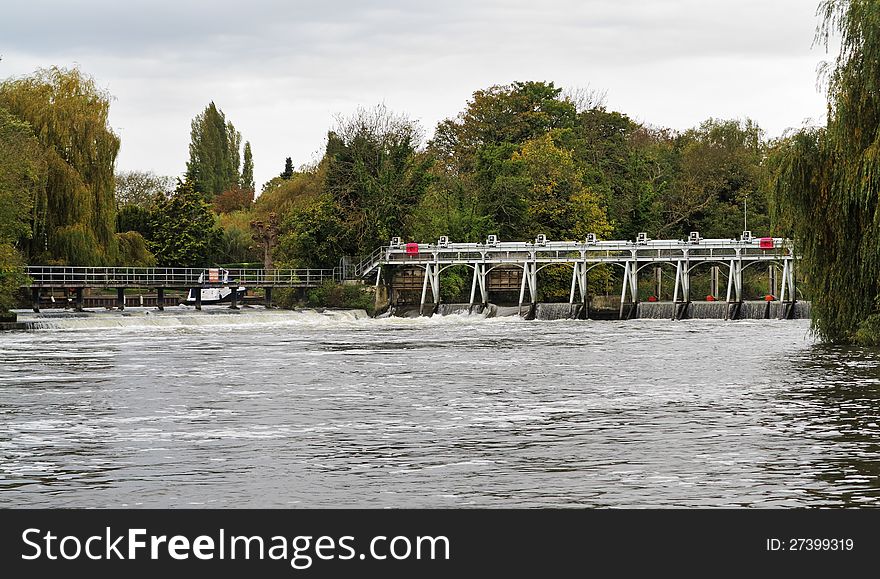 Flood water flowing through a Weir on the River Thames in England. Flood water flowing through a Weir on the River Thames in England