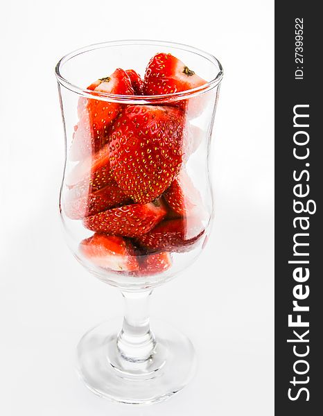 Strawberry pieces in glass side view on white background. It is good for diet, good for health and having a lot of nutrition