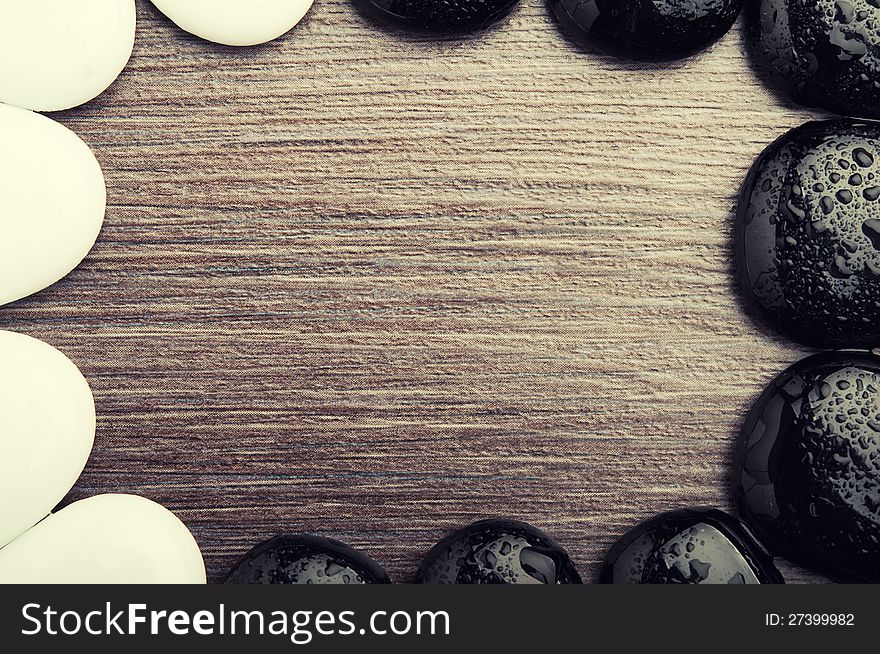 Abstract background spa. stones, pebbles, white and black on a wooden texture. Abstract background spa. stones, pebbles, white and black on a wooden texture