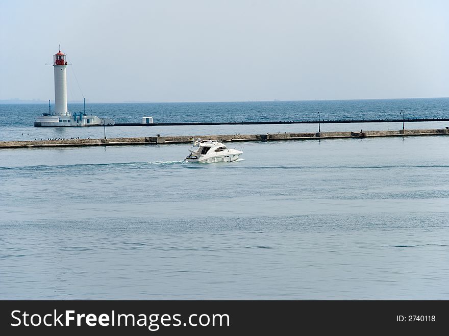 Modern boat go to sea near lighthouse