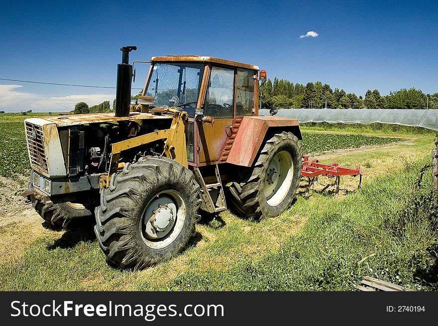 Farm tractor in a sunny agricultural landscape