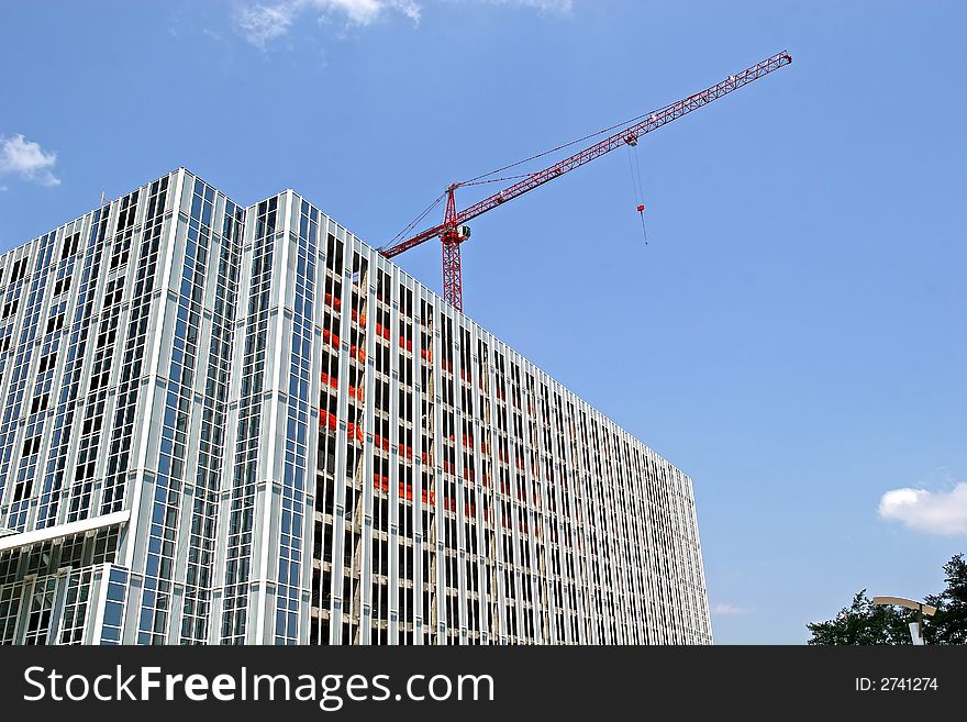 Steel construction tower with red crane on top. Steel construction tower with red crane on top