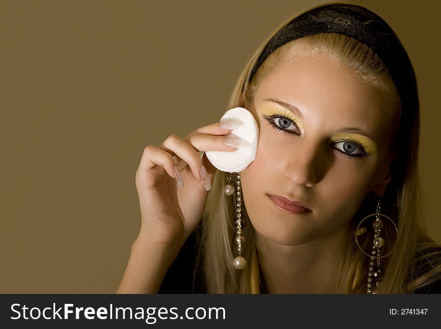 Young attractive blond girl applying face pack