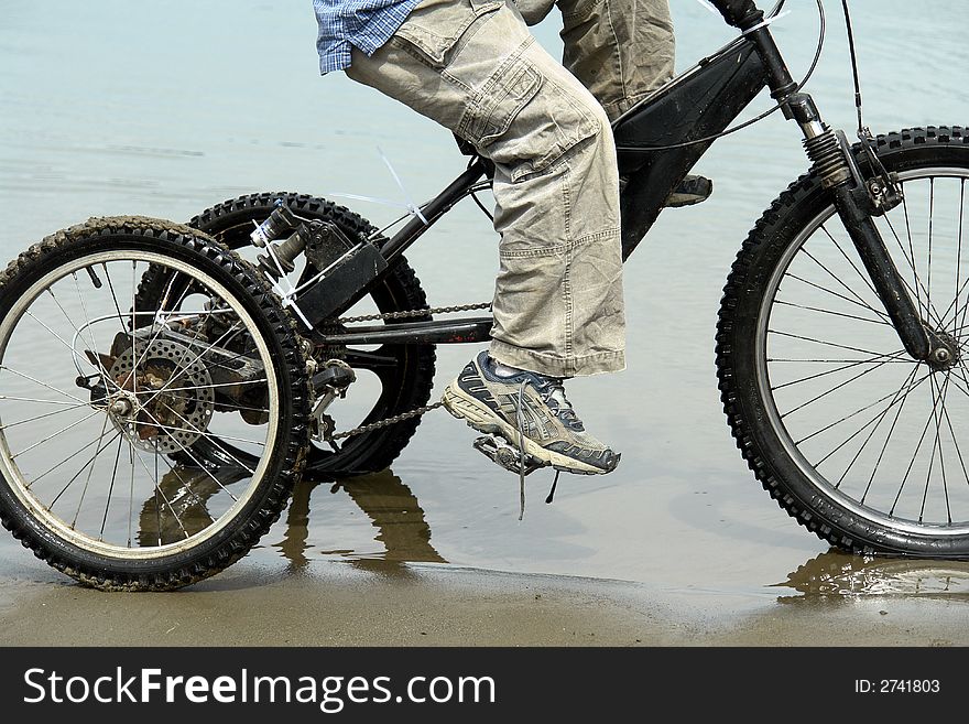 Young boy riding his bicycle along the shore. Young boy riding his bicycle along the shore