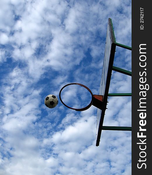 Outdoor basketball, lovely cloudy background, football in air,