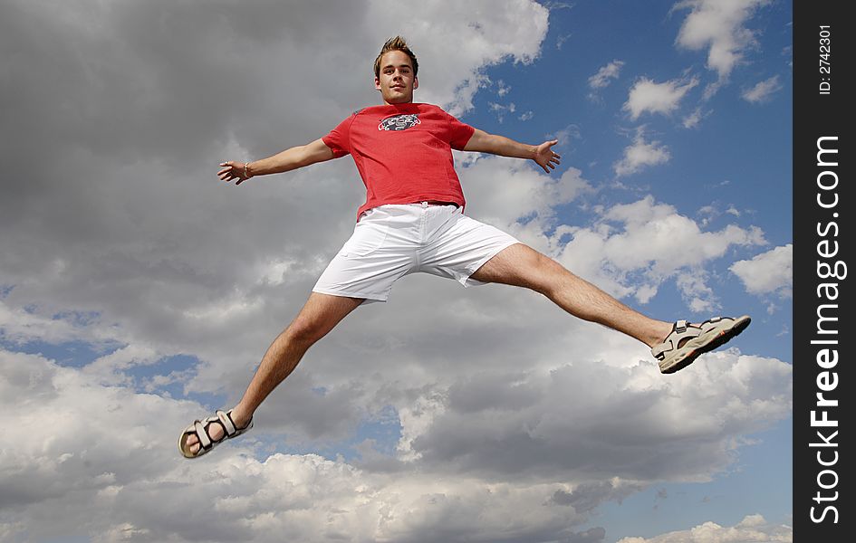 Young man happily jumping against blue sky. Young man happily jumping against blue sky.