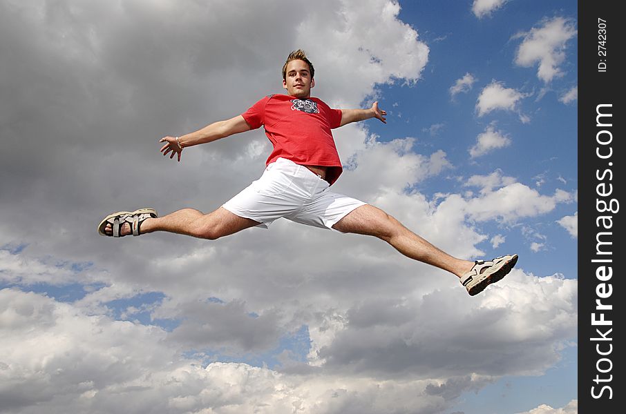 Young man happily jumping against blue sky. Young man happily jumping against blue sky.