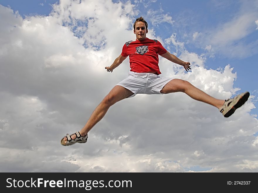 Young man happily jumping against blue sky. Young man happily jumping against blue sky.