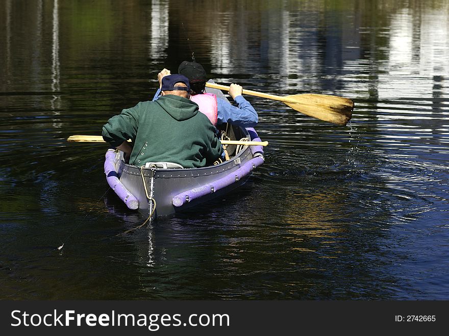 Father and son padding in a canoe. Father and son padding in a canoe