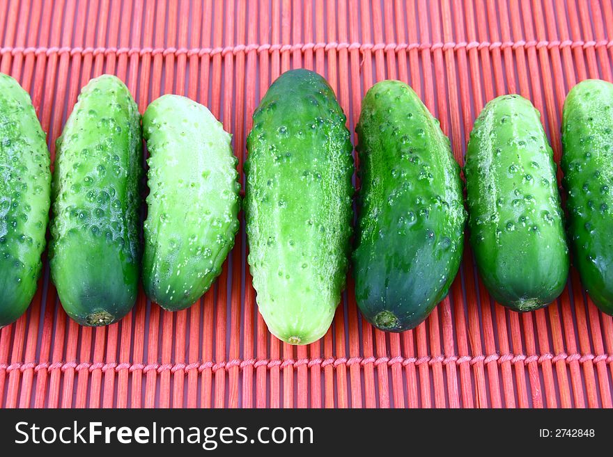 A Cucumber progressively sliced on a white background