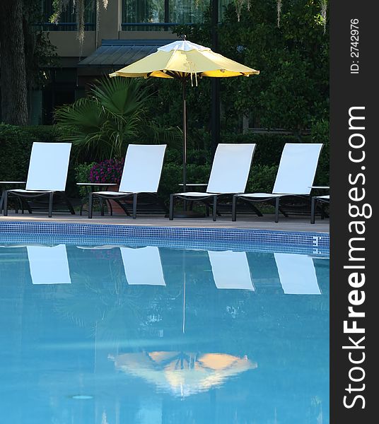 Umbrella and Chairs Reflected in Pool. Umbrella and Chairs Reflected in Pool