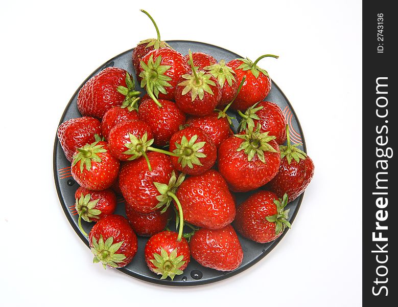 Ripe red strawberry on a black plate. Ripe red strawberry on a black plate.