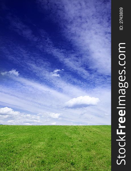 Beautiful green field and blue sky with dramatic clouds