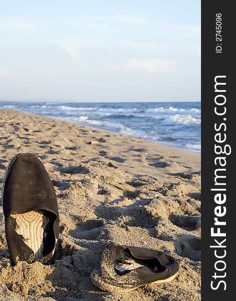 Stylish beach shoes photographed on the sand at sunset. Composition leaves a lot of space for typing. Stylish beach shoes photographed on the sand at sunset. Composition leaves a lot of space for typing