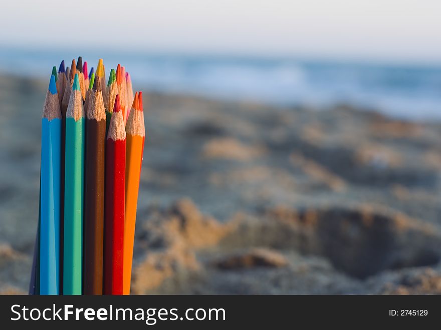 Color pencils in the sand. Color pencils in the sand.