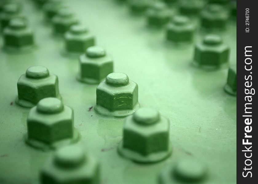 Many green screws in a row.