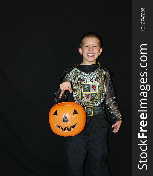 A little boy in a Halloween costume trick or teats