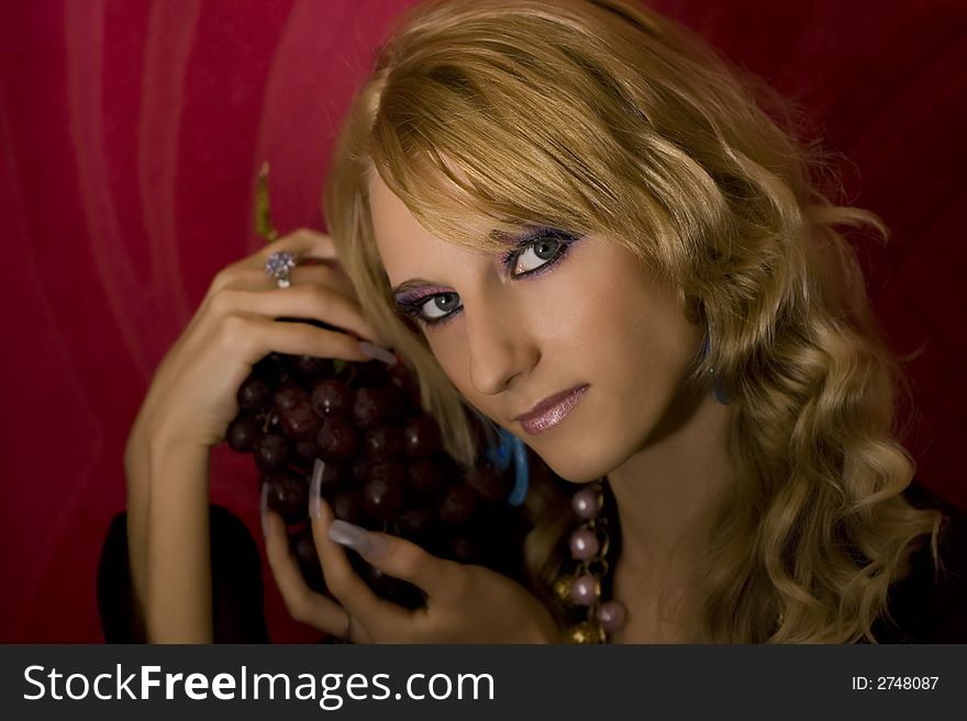 Young beautiful  blond girl with grapes